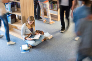 Student sitting floor in library blur motion