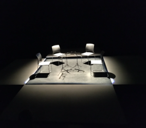 string quartet 2022 
Image of dark room with three white chairs.