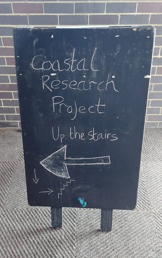 Blackboard sign directing participants to the Coastal Research Project meeting room