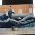 Tiny laundry hangs in front of a big wave