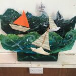 Paper boats appear to float on a paper sea