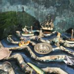 A scene in miniature of a stormy sea in front of the cliffs of Borth