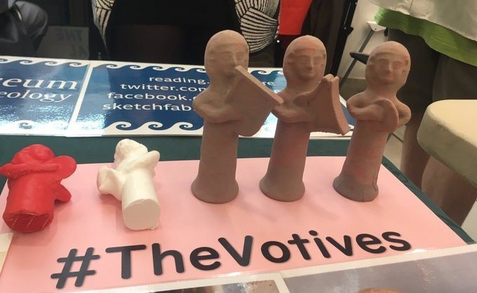 3D-printed replicas of ancient Cypriot figurines. The display reads '#TheVotives'