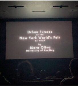A cinema screen reads 'Urban Futures at the New York World's Fair of 1939 by Mara Oliva University of Reading'
