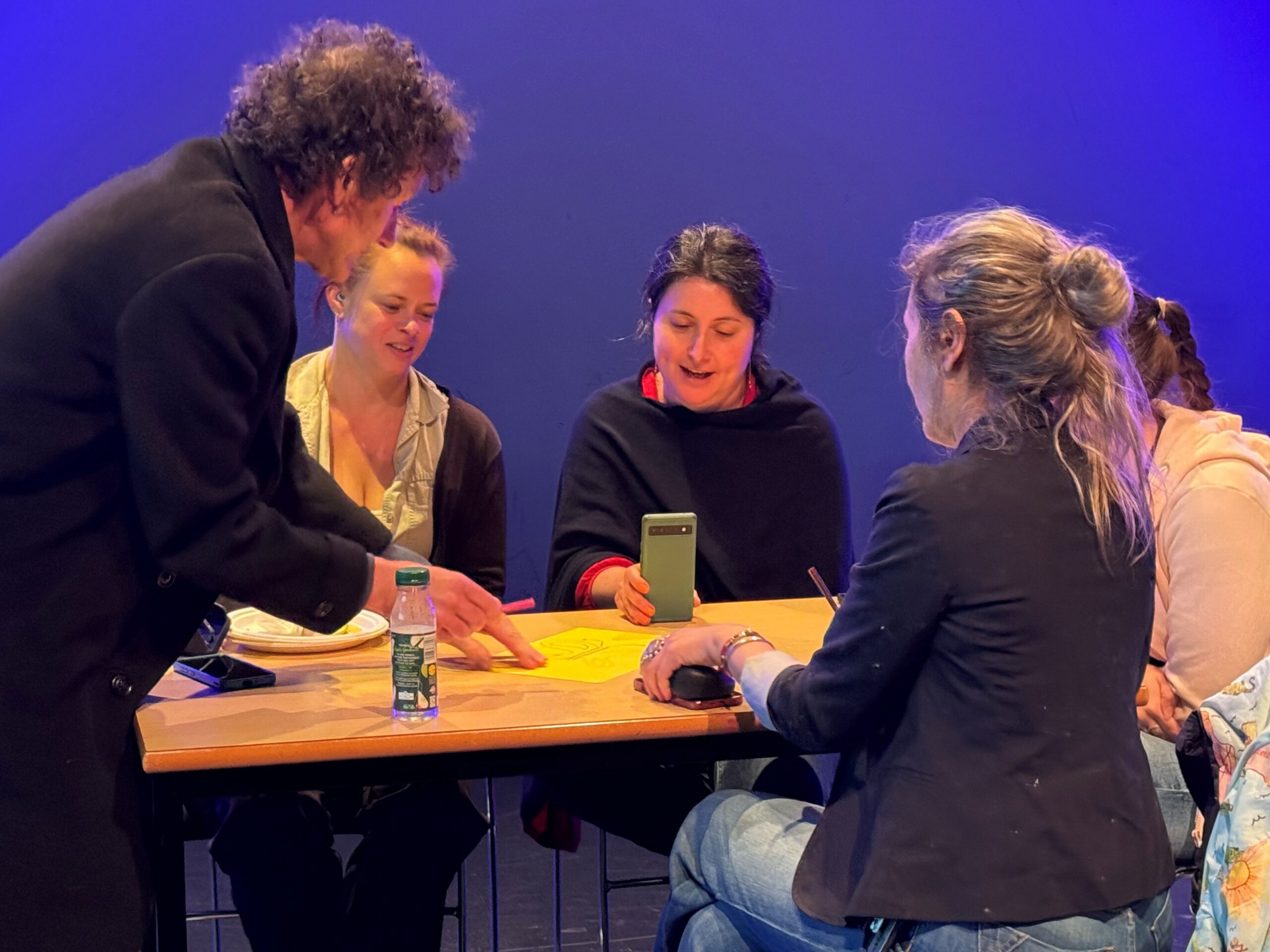 Participants gathered around a table, with a mobile phone
