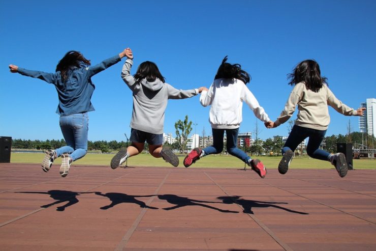 children jumping in the air holding hands