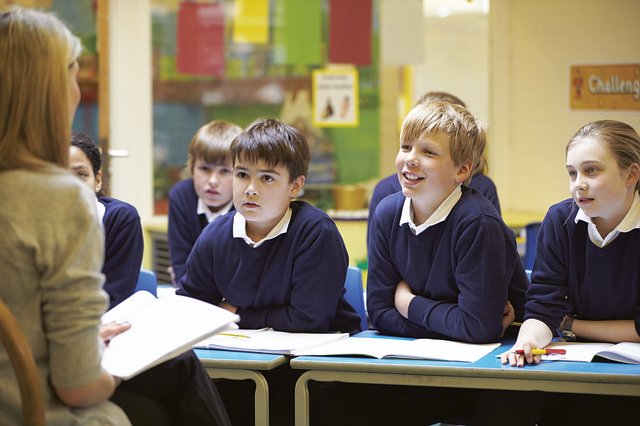 schoolchildren listening to a teacher talk
