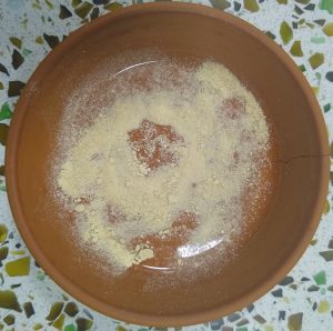 light sandy coloured powder in cracked earthenware disch