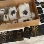 A box containing leaden pilgrim signs surrounded by engraved artworks based on them