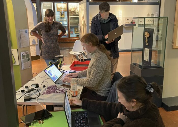 Members of Lynn Museum staff help provide finds from display for portable XRF analysis conducted by the University of Reading