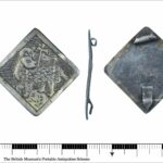Silver square or lozenge shaped silver panel featuring an engraved Lamb and cross. Full description at https://finds.org.uk/database/artefacts/record/id/992821