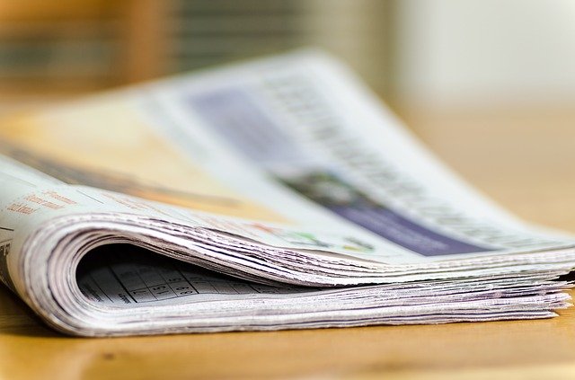 colour photograph of folded newspaper, in focus to foreground blurred to background
