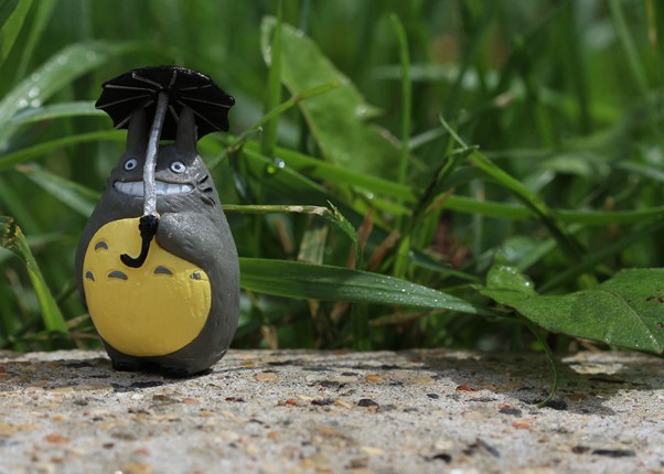 A figurine of Totoro under an umbrella