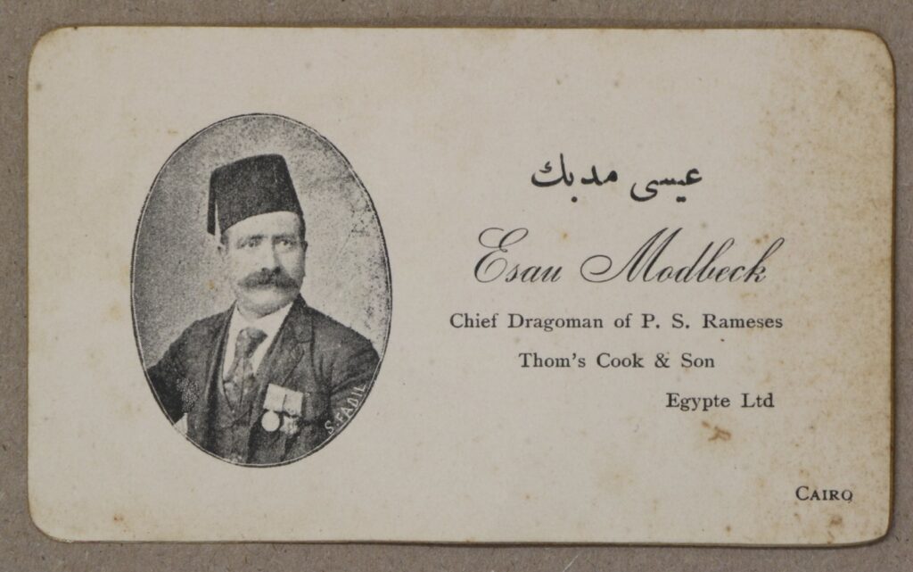 The business card of Esau Modbeck, a dragoman. In the photograph his photograph he is wearing a tarboush – at that time the preferred headgear of modern, educated gentlemen in Egypt – and medals, advertising his military service and thus loyalty to the British. 