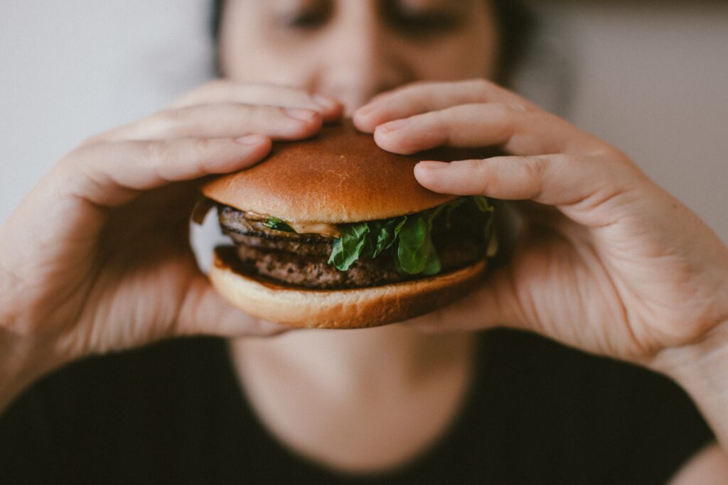 A woman holding a beef burger