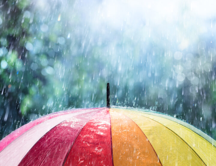Rain hits a rainbow coloured umbrella