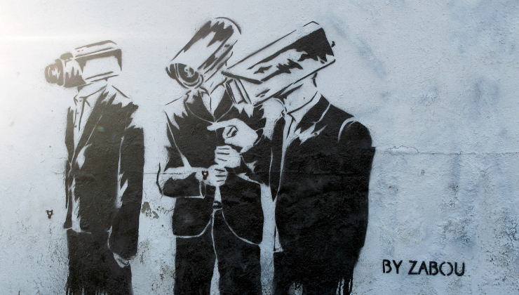 Black and white image by artist Zabou depicting three figures in suits with each replaced by security cameras.