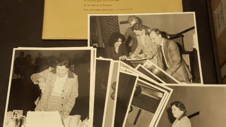 Three black and white photographs of Dr Nellie B. Eales at her 90th birthday party. She is seen standing beside the cake in a smart suit, cutting the cake and handing out slices of the cake on a tray.