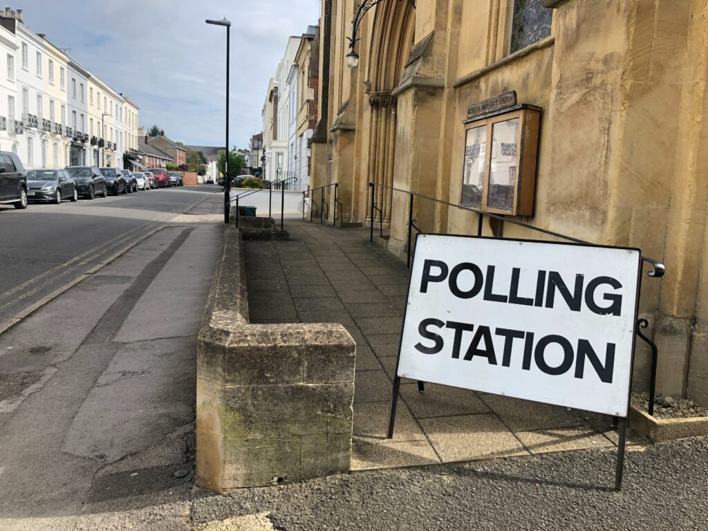 A polling station sign on the street.