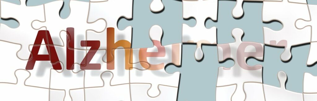 A jigsaw puzzle with some pieces missing so that the word 'Alzheimer's' is partially visible