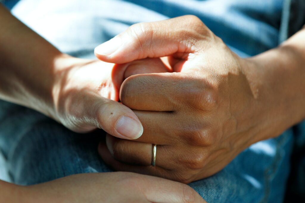 Close up of a hospital patient's hand being held