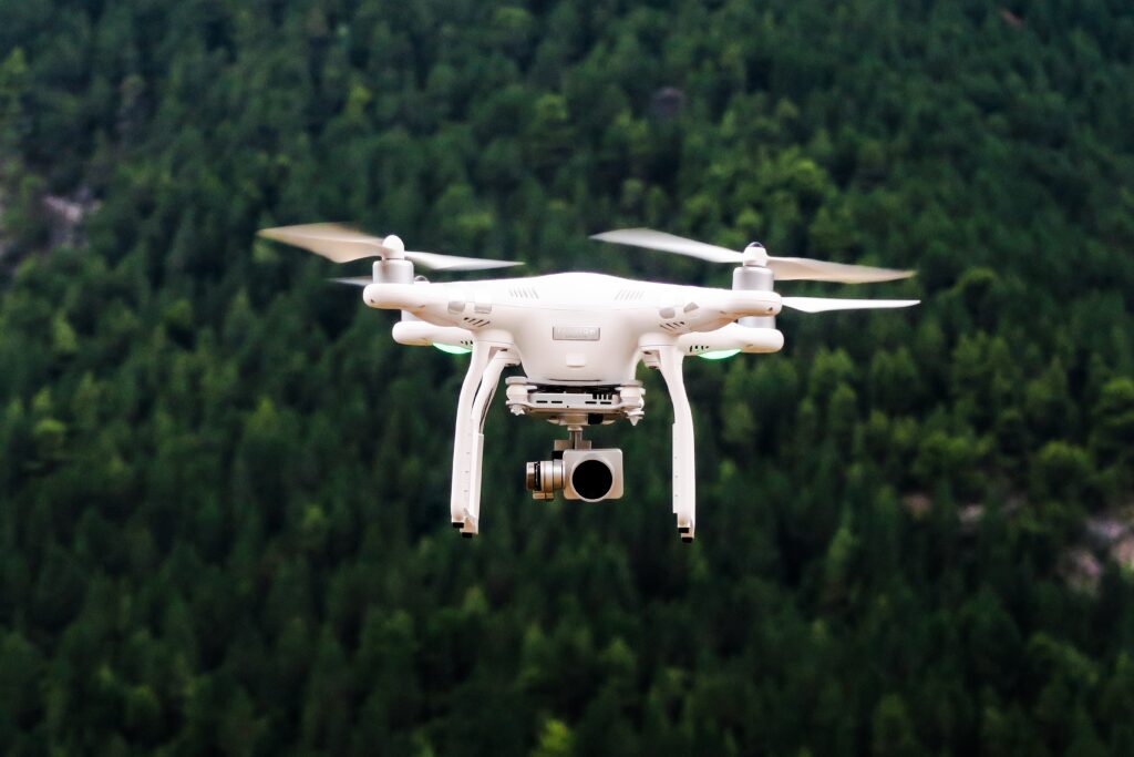 A drone with camera flying about a forest