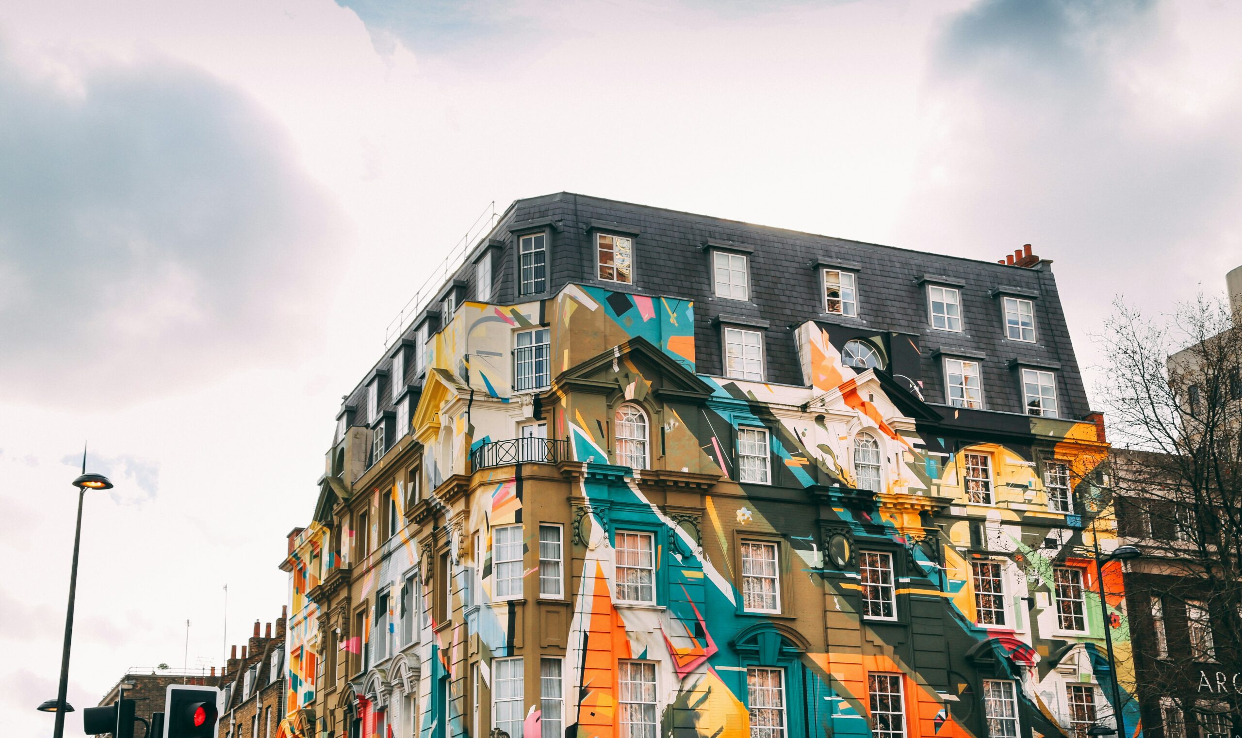 A large apartment building in Shoreditch, painted over with bold, colourful murals