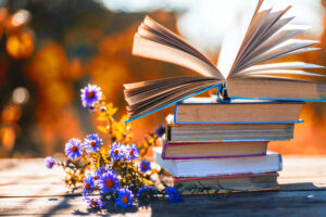 Open book on wooden table on natural background. Soft focus