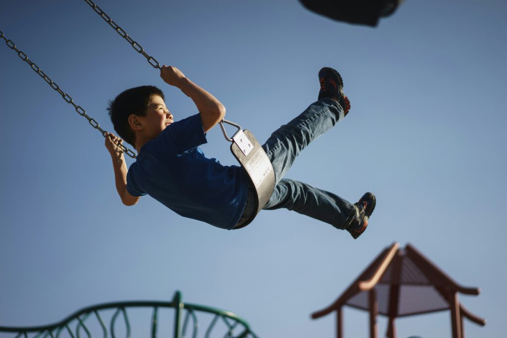 boy on a swing against blue sky