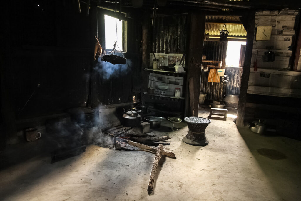 A kitchen in a traditional house with smoke from a tea kettle heated with wood fire in a village in Nagaland.