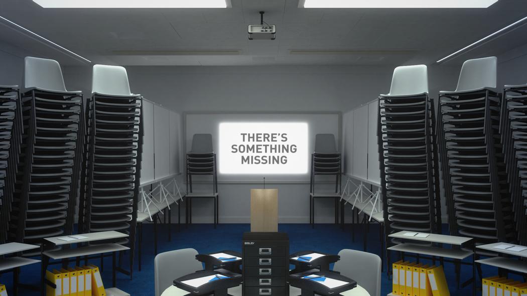 Screen in an office that reads "THERE'S SOMETHING MISSING"