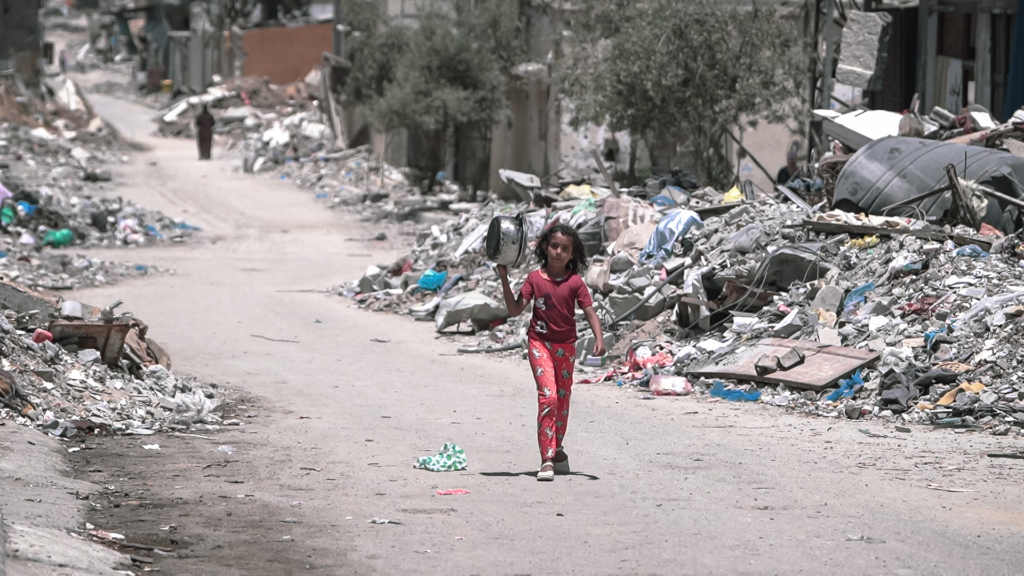 A girl walks along a street in Gaza to get food during the war.