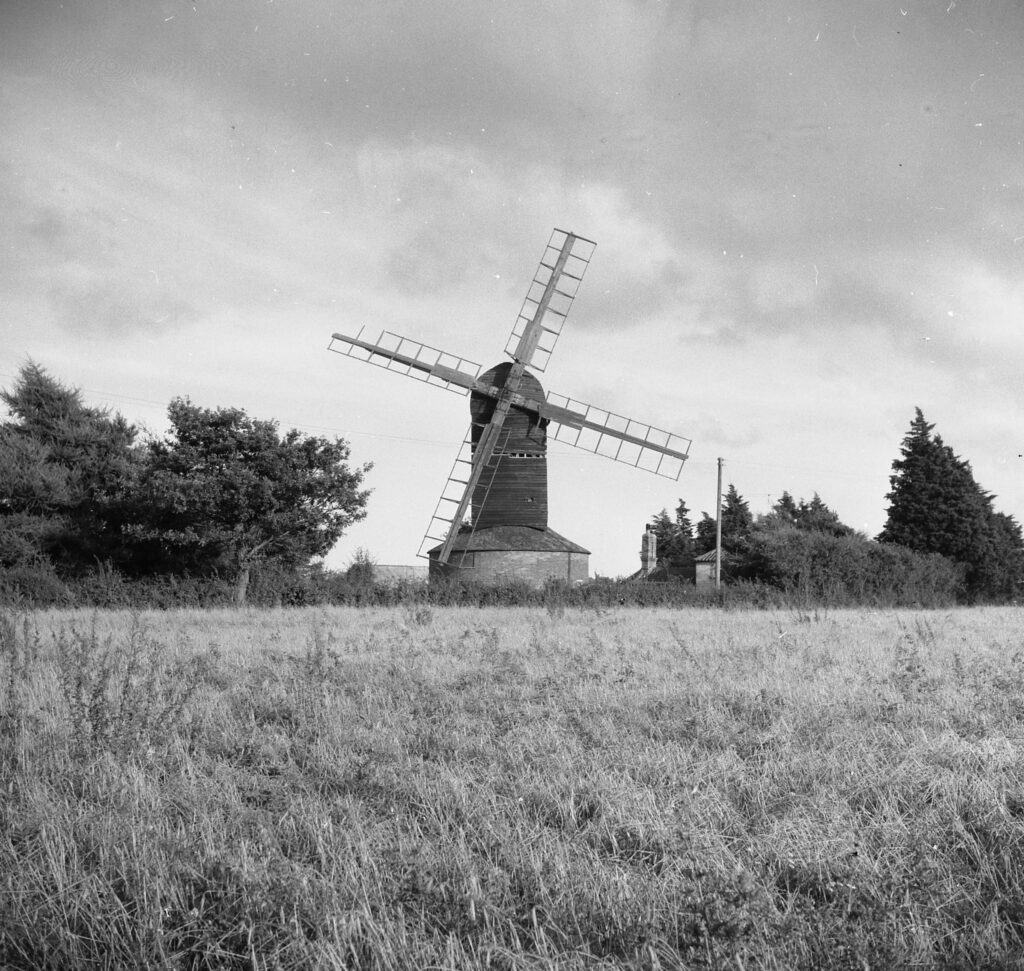 Black and white photo of a windmill in a meadow