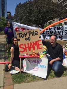 Hilary with Toy Pile of Shame sign