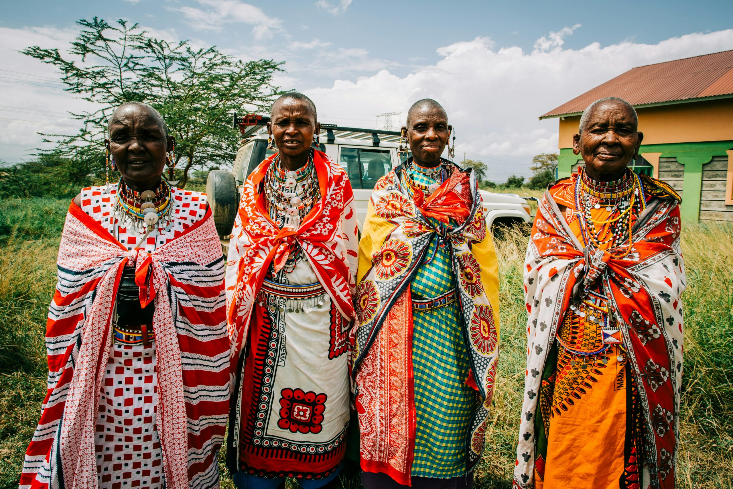four people in traditional dress in rural kenya